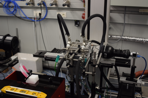 Laser Doppler Anemometry (LDA) probe on one side and chemiluminescence recording camera on the other side.  Camera is equipped with telecentric lens